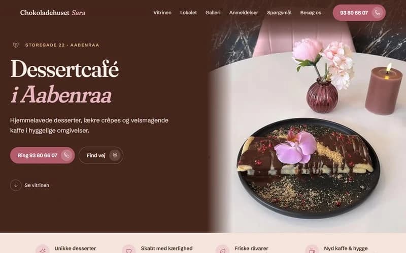 Skærmbillede af øverste del af forsiden på et hjemmesideudkast til dessertcafé. Varm bordeaux/brun flade med stor serif-overskrift og foto af en dessert på en tallerken med lys.