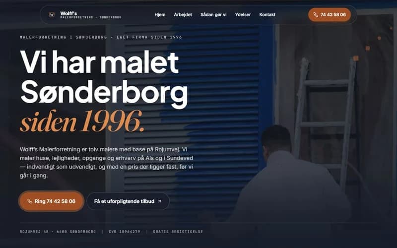 Skærmbillede af øverste del af forsiden på et hjemmesideudkast til maler. Mørk blå flade med foto af en blå stålfacade og en stige, sans-overskrift med kursiv guld-serif.